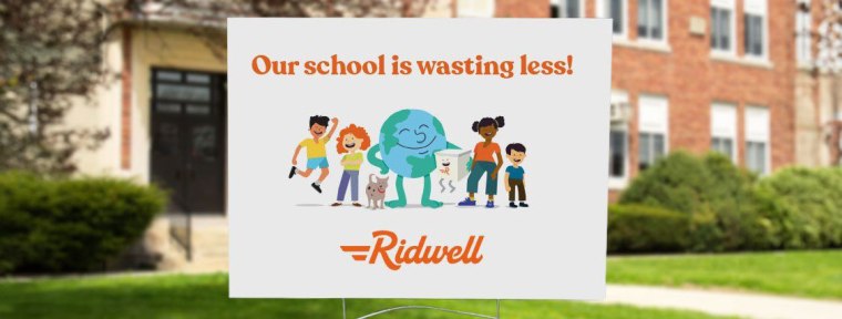 Lawn sign placed in front of a school reads "Our school is wasting less! Ridwell"