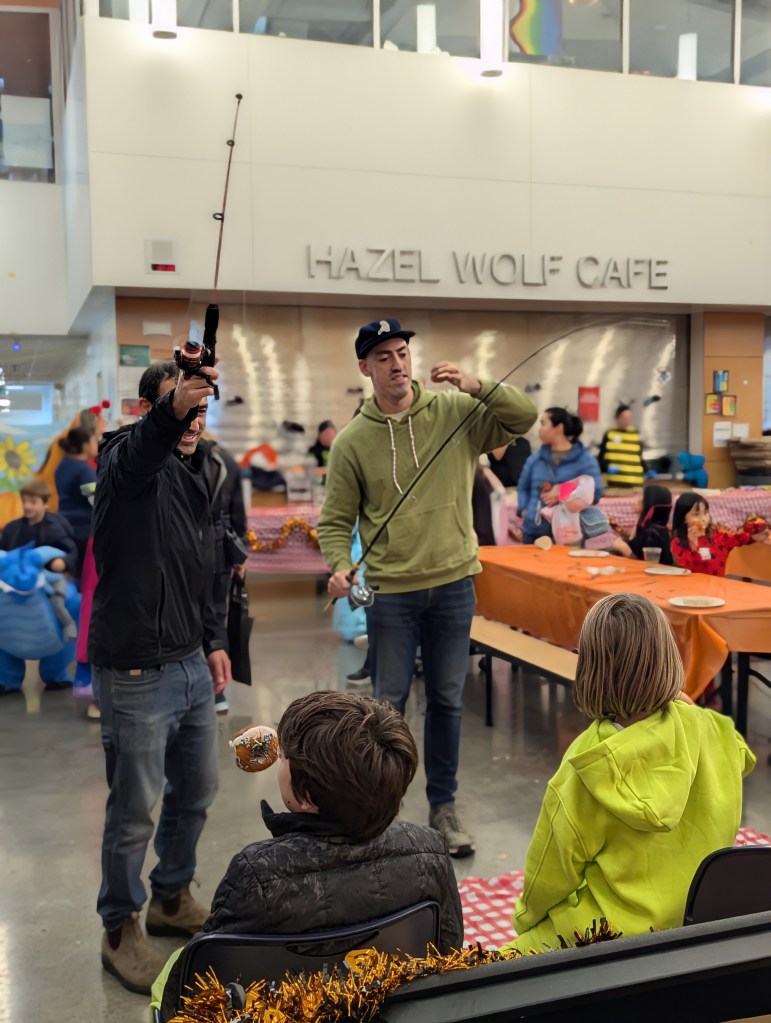 Caregivers dangle donuts from fishing poles for students to bite without using their hands.