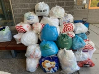 A pile of plastic shopping bags filled with plastic film stacked on top of each other