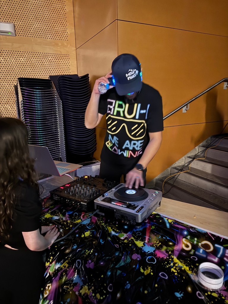 A parents djs the dance from the dj table.