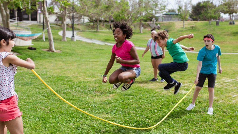 Two elementary school children jump rope at the same time.