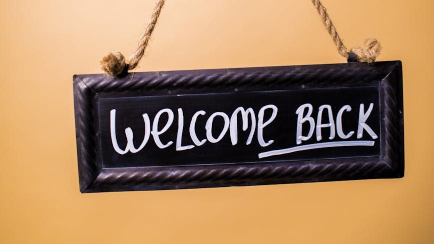 Chalk sign that reads "Welcome Back"