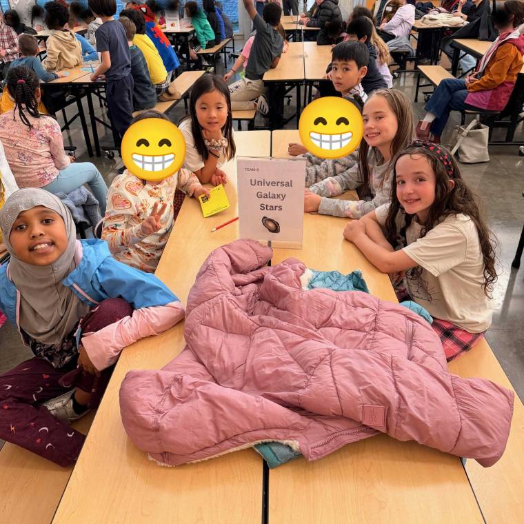 The Universal Galaxy Stars team sitting at a table and smiling at the camera.